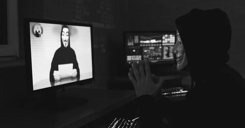 Monochrome image of a masked hacker on a video call, showcasing cyber security themes.