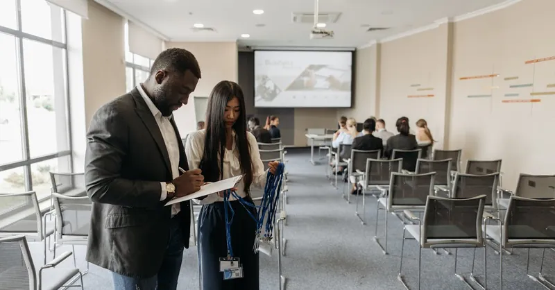 A diverse team prepares for a business conference in a modern office setting.