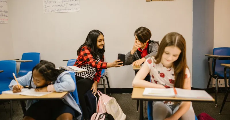 A diverse group of children interacting and studying in a school classroom.