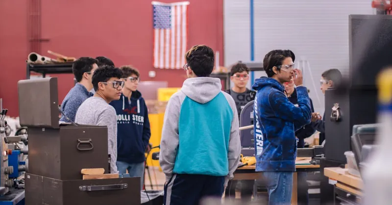 Teenagers working together in an educational workshop, promoting teamwork and learning.
