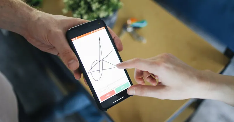 Two people completing a digital transaction with electronic signature on a smartphone screen.